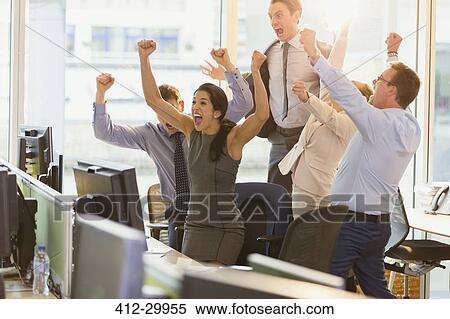 Stock Photography - Exuberant business people cheering with arms raised in office. Fotosearch