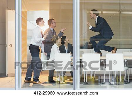 Exuberant businessman gesturing with fists on top of conference table View Large Photo Image Stock Image - Exuberant businessman gesturing with fists on top of conference table. Fotosearch