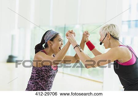 Stock Photograph - Exuberant fitness instructor and student celebrating. Fotosearch