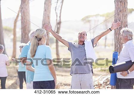 Stock Photography - Exuberant senior man after yoga class in sunny park. Fotosearch