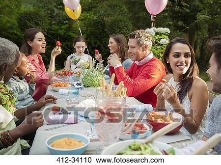 Family and friends enjoying birthday garden party at patio table View Large Photo Image Stock Image - Family and friends enjoying birthday garden party at patio table. Fotosearch