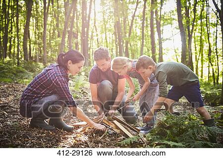 Family building campfire in forest View Large Photo Image Stock Photograph - Family building campfire in forest. Fotosearch