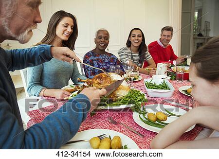 Picture - Family enjoying Christmas turkey dinner at table. Fotosearch