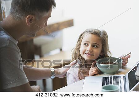 Father and daughter eating breakfast at laptop View Large Photo Image Stock Image - Father and daughter eating breakfast at laptop. Fotosearch