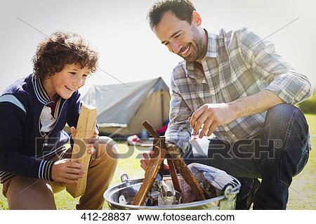 Father and son building campfire View Large Photo Image Stock Photo - Father and son building campfire. Fotosearch