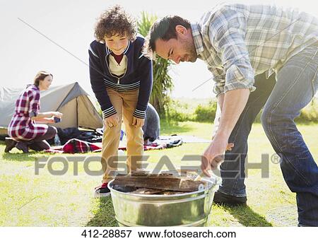 Father and son building campfire View Large Photo Image Stock Photo - Father and son building campfire. Fotosearch