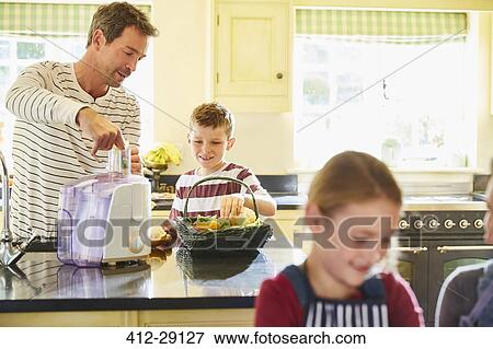 Father and son juicing vegetables in kitchen View Large Photo Image Stock Photo - Father and son juicing vegetables in kitchen. Fotosearch