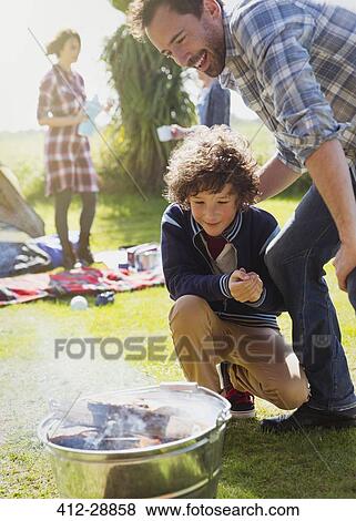 Father and son watching campfire ignite View Large Photo Image Stock Photo - Father and son watching campfire ignite. Fotosearch