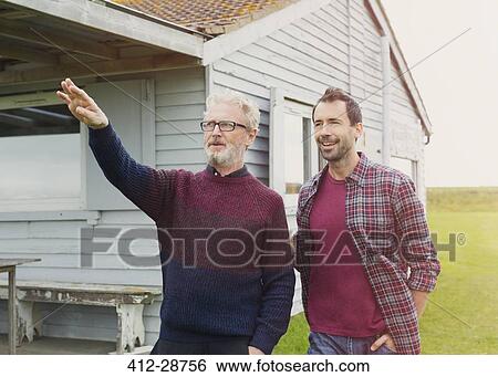 Father gesturing to son outside house View Large Photo Image Stock Photograph - Father gesturing to son outside house. Fotosearch