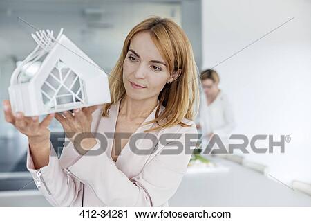 Female architect examining model in office View Large Photo Image Stock Image - Female architect examining model in office. Fotosearch