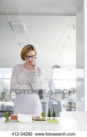 Female architect examining model in conference room View Large Photo Image Stock Image - Female architect examining model in conference room. Fotosearch
