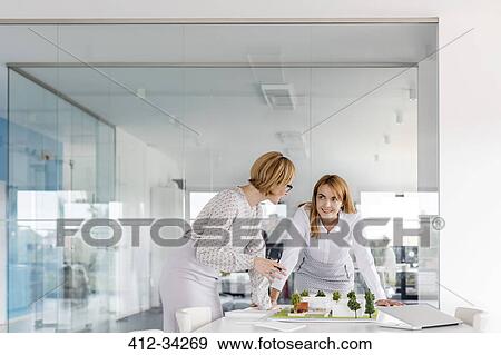Female architects discussing model in conference room View Large Photo Image Stock Photo - Female architects discussing model in conference room. Fotosearch