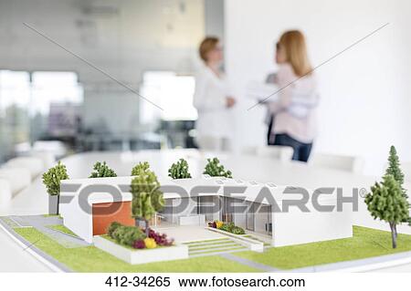 Female architects talking behind building model View Large Photo Image Stock Photography - Female architects talking behind building model. Fotosearch