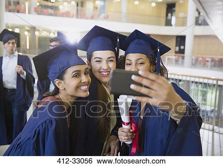 Female college graduates in cap and gown taking selfie View Large Photo Image Stock Photograph - Female college graduates in cap and gown taking selfie. Fotosearch
