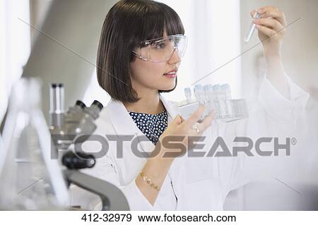 Female college student conducting scientific experiment examining vials in science laboratory classroom View Large Photo Image Stock Photo - Female college student conducting scientific experiment examining vials in science laboratory classroom. Fotosearch