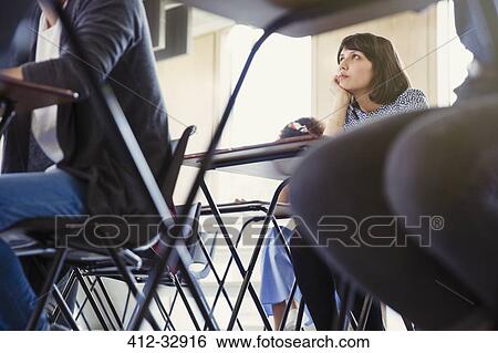 Stock Photograph - Female college student listening classroom. Fotosearch