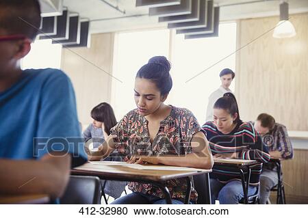 Female college student taking test at desk in classroom View Large Photo Image Stock Image - Female college student taking test at desk in classroom. Fotosearch