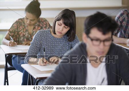 Female college student taking test at desk in classroom View Large Photo Image Stock Photo - Female college student taking test at desk in classroom. Fotosearch