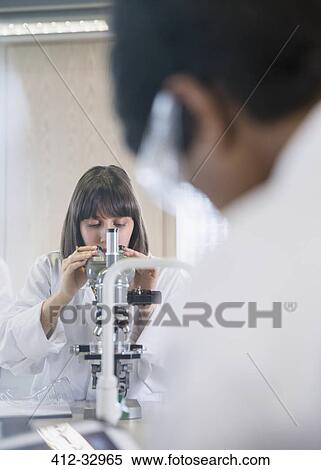 Female college student using microscope conducting scientific experiment in science laboratory classroom View Large Photo Image Stock Photography - Female college student using microscope conducting scientific experiment in science laboratory classroom. Fotosearch