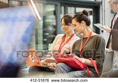 Stock Photograph - Female college students using laptop. Fotosearch
