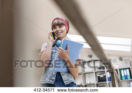 Female design professional talking on cell phone in office View Large Photo Image Stock Image - Female design professional talking on cell phone in office. Fotosearch