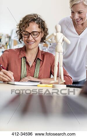 Female design professionals with artists figure sketching in office View Large Photo Image Stock Photograph - Female design professionals with artists figure sketching in office. Fotosearch