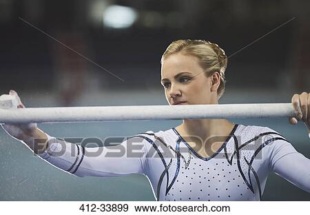 Female gymnast chalking uneven bars View Large Photo Image Stock Photo - Female gymnast chalking uneven bars. Fotosearch