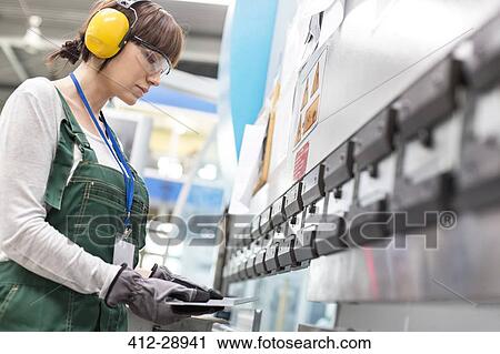 Stock Image - Female worker working in factory. Fotosearch