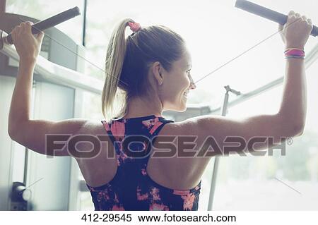 Fit woman doing lat pulldowns on equipment at gym View Large Photo Image Stock Photography - Fit woman doing lat pulldowns on equipment at gym. Fotosearch