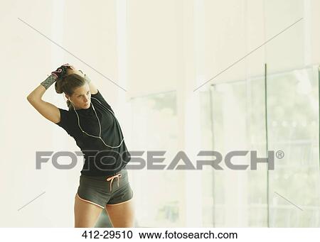 Fit woman stretching arm in gym studio mirror View Large Photo Image Stock Image - Fit woman stretching arm in gym studio mirror. Fotosearch