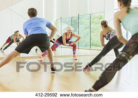 Stock Image - Fitness instructor leading aerobics class. Fotosearch