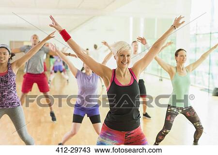 Stock Image - Fitness instructor leading aerobics class. Fotosearch