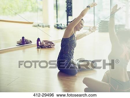 Stock Photograph - Fitness instructor leading class in stretching. Fotosearch