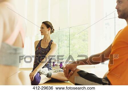Stock Photograph - Fitness instructor leading class in twisting stretch. Fotosearch
