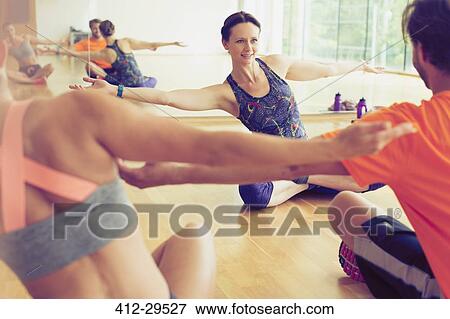 Fitness instructor with arms outstretched leading class in studio View Large Photo Image Stock Photo - Fitness instructor with arms outstretched leading class in studio. Fotosearch