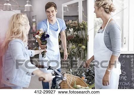 Florist giving customer bouquet in flower shop View Large Photo Image Stock Photo - Florist giving customer bouquet in flower shop. Fotosearch