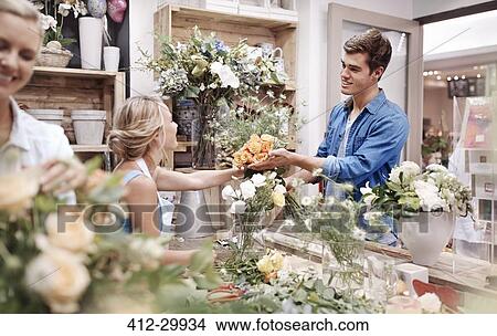 Florist giving man bouquet at flower shop View Large Photo Image Picture - Florist giving man bouquet at flower shop. Fotosearch