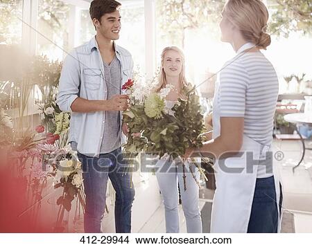 Florist helping customers select flowers in flower shop View Large Photo Image Picture - Florist helping customers select flowers in flower shop. Fotosearch
