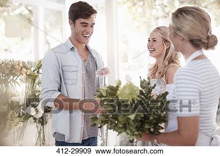 Florist preparing bouquet for couple in flower shop View Large Photo Image Stock Photo - Florist preparing bouquet for couple in flower shop. Fotosearch