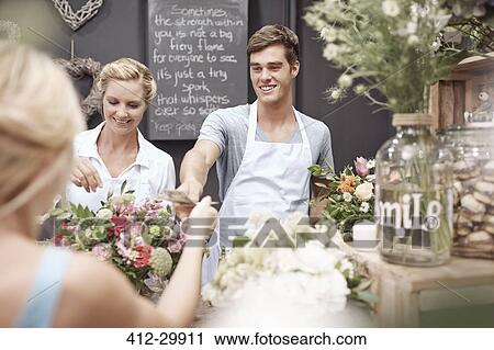 Florist taking money from woman in flower shop View Large Photo Image Stock Image - Florist taking money from woman in flower shop. Fotosearch