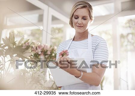 Stock Photography - Florist with clipboard in flower shop. Fotosearch