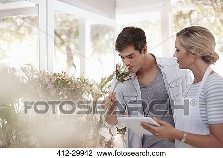 Florist with digital tablet helping man select flowers in flower shop View Large Photo Image Stock Image - Florist with digital tablet helping man select flowers in flower shop. Fotosearch