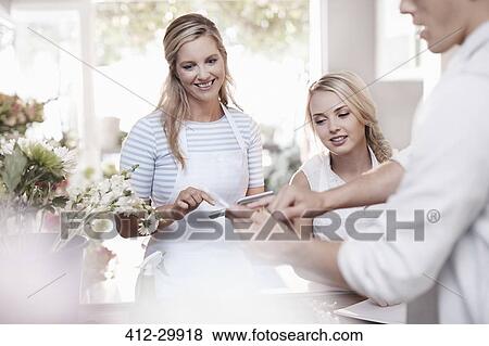 Florists talking in flower shop View Large Photo Image Stock Photo - Florists talking in flower shop. Fotosearch