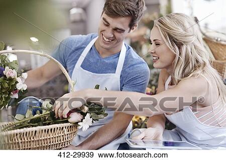 Florists with digital tablet discussing flowers in basket View Large Photo Image Stock Photo - Florists with digital tablet discussing flowers in basket. Fotosearch