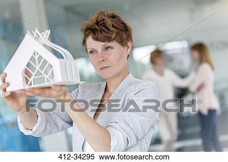 Focused female architect examining model in office View Large Photo Image Stock Photography - Focused female architect examining model in office. Fotosearch