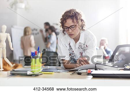 Stock Photo - Focused female design professional planning in office. Fotosearch