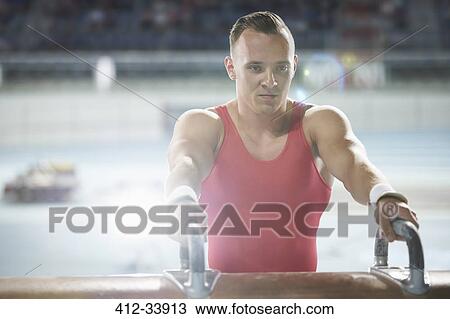 Stock Image - Focused male gymnast at pommel horse. Fotosearch