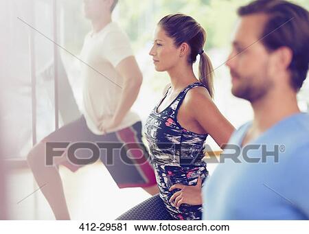 Focused woman lunging in exercise class View Large Photo Image Stock Image - Focused woman lunging in exercise class. Fotosearch