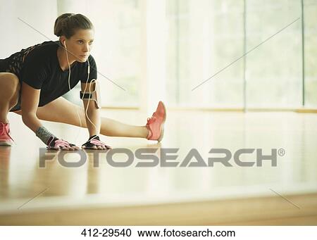 Focused woman stretching leg at gym studio mirror View Large Photo Image Stock Image - Focused woman stretching leg at gym studio mirror. Fotosearch