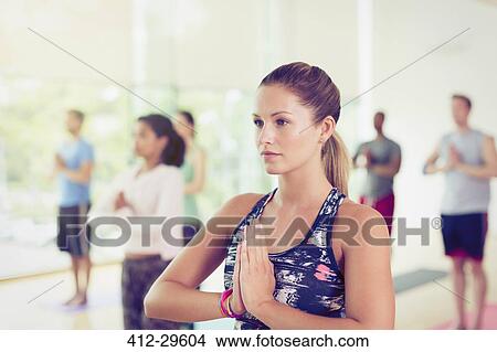 Picture - Focused woman with hands at prayer position in yoga class. Fotosearch